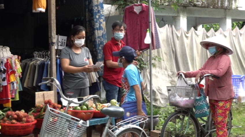 Người bán vé số đợi tiêm vắc xin ngừa Covid-19